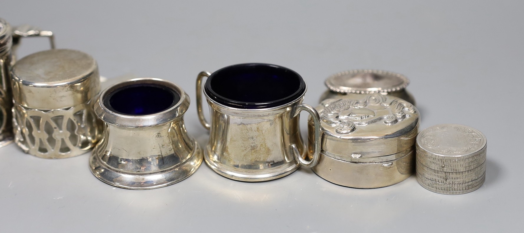 A small group of collectable small silver and white metal items including two pairs of 19th century sugar tongs(one a.f.), later condiments, match sleeve, dish pill box, etc.